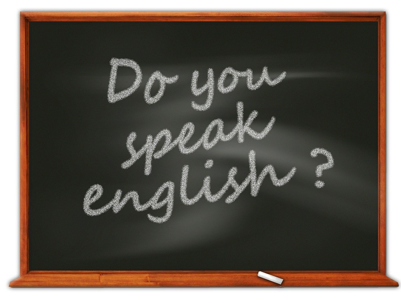 The question 'Do you speak English?' handwritten in white chalk on a black chalkboard with a piece of chalk resting at the bottom.